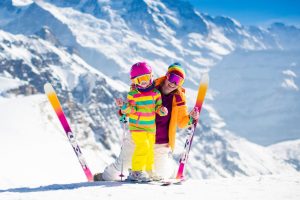 63589457 - family ski vacation. group of skiers in swiss alps mountains. mother and child skiing in winter. parents teach kids alpine downhill skiing. ski gear and wear, safe helmets.